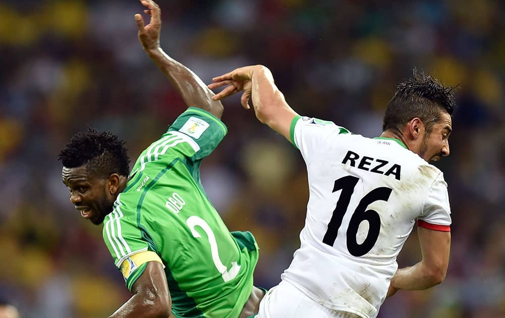 Nigeria's Joseph Yobo, left, challenges Iran's Reza Ghoochannejhad during the group F World Cup soccer match between Iran and Nigeria at the Arena da Baixada in Curitiba, Brazil.