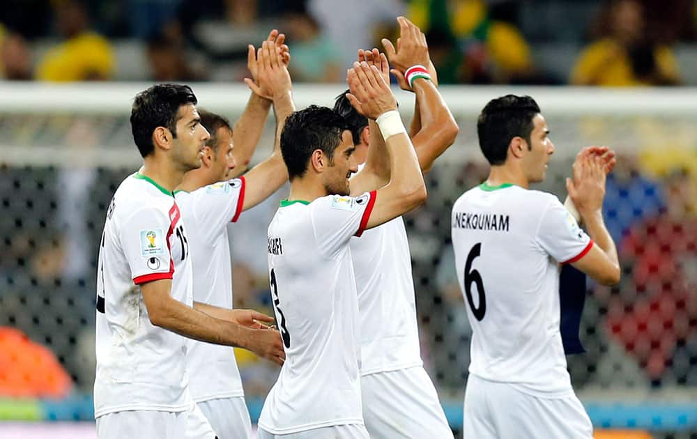 Iranian players applaud spectators following their 0-0 tie with Nigeria during the group F World Cup soccer match between Iran and Nigeria at the Arena da Baixada in Curitiba, Brazil.