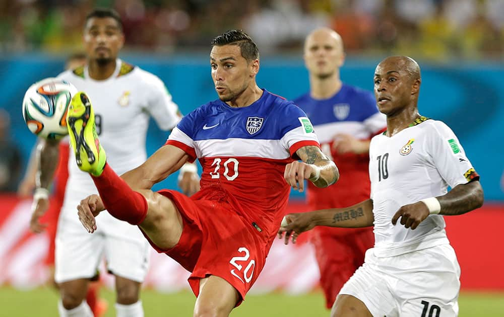 United States' Geoff Cameron, left, kicks the ball clear from Ghana's Andre Ayew during the group G World Cup soccer match between Ghana and the United States at the Arena das Dunas in Natal, Brazil.