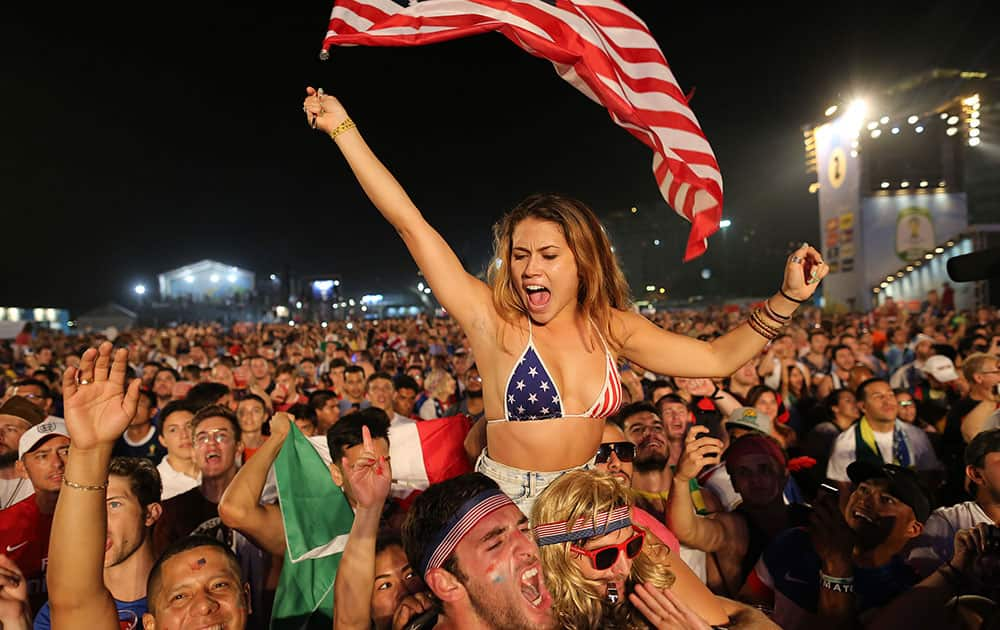 Soccer fans of the U.S. national soccer team cheer minutes before a live broadcast of the soccer World Cup match between USA and Ghana, inside the FIFA Fan Fest area on Copacabana beach, Rio de Janeiro, Brazil.