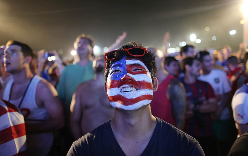 A soccer fan of the U.S. national soccer team watches a live broadcast of the soccer World Cup match between USA and Ghana, inside the FIFA Fan Fest area on Copacabana beach, Rio de Janeiro, Brazil.