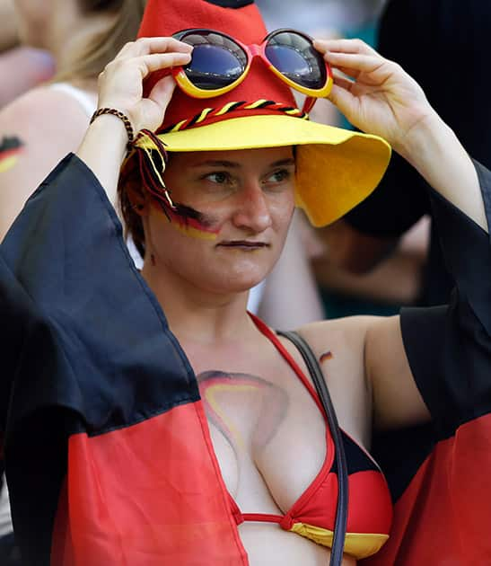 A German fan adjusts her sunglasses before the group G World Cup soccer match between Germany and Portugal at the Arena Fonte Nova in Salvador, Brazil.