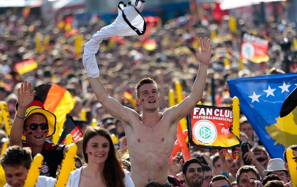 German soccer fans celebrate the kick off of their team's first game at the World Cup 2014 at a public viewing zone called 'fan mile' in Berlin.