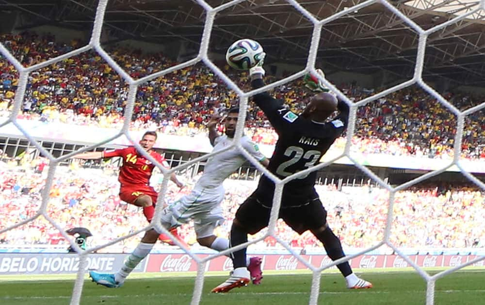 Belgium's Dries Mertens, left, scores his side's 2nd goal past Algeria's goalkeeper Rais M'Bolhi, right, during the group H World Cup soccer match between Belgium and Algeria at the Mineirao Stadium in Belo Horizonte, Brazil.