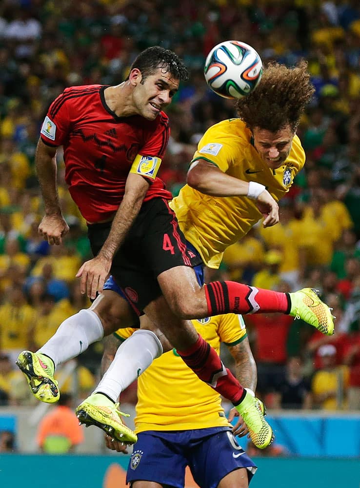 Mexico's Rafael Marquez, left, and Brazil's David Luiz try to head the ball simultaneously during the group A World Cup soccer match between Brazil and Mexico at the Arena Castelao in Fortaleza, Brazil.