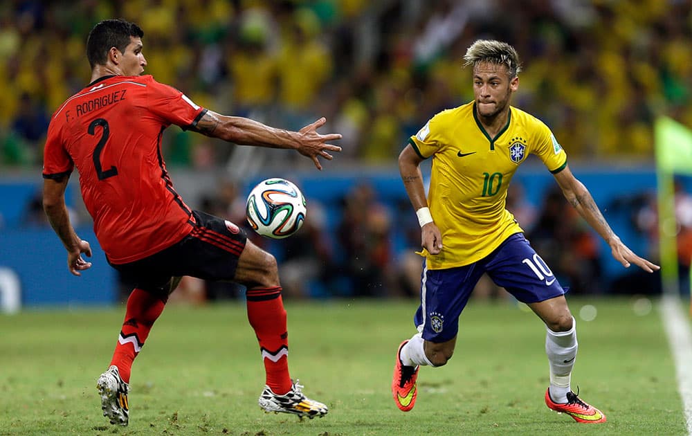 Brazil's Neymar, right, gets past Mexico's Francisco Rodriguez during the group A World Cup soccer match between Brazil and Mexico at the Arena Castelao in Fortaleza, Brazil.