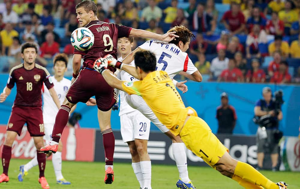 South Korea's goalkeeper Jung Sung-ryong punches the ball away from Russia's Alexander Kokorin and South Korea's Kim Young-gwon during the group H World Cup soccer match between Russia and South Korea at the Arena Pantanal in Cuiaba, Brazil.