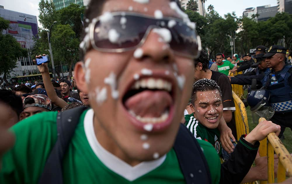 Mexico soccer fans celebrate at the Independence Monument after their team tied with Brazil in their 2014 World Cup soccer match, in Mexico City.