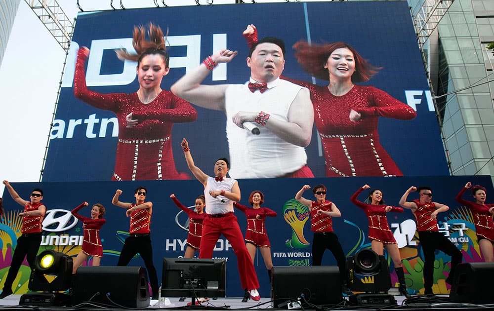 South Korean rapper PSY,center, performs before a TV broadcasting of the group H World Cup soccer match between Russia and South Korea, at a public viewing venue in Seoul, South Korea.