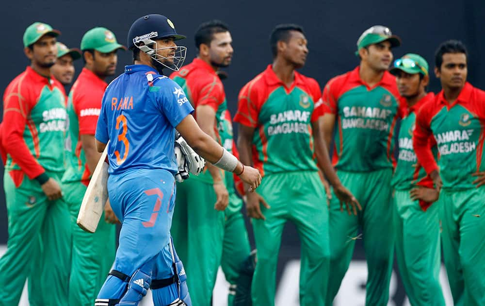 India's captain Suresh Raina, foreground, walks back to the pavilion after his dismissal during their second one-day International cricket match against Bangladesh in Dhaka, Bangladesh.