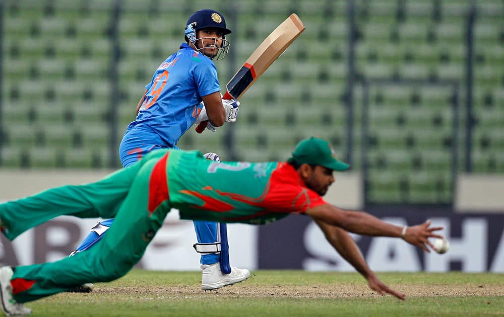 India's Umesh Yadav plays a shot as Bangladesh's Mashrafe Mortaza dives to stop the ball during their second one-day International cricket match against Bangladesh in Dhaka, Bangladesh.