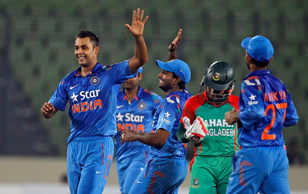 India's Stuart Binny, left, celebrates with teammates after the wicket of Bangladesh's captain Mushfiqur Rahim, during their second one-day International cricket match in Dhaka, Bangladesh.