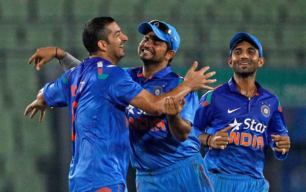 India's Mohit Sharma, left, celebrates with captain Suresh Raina, center, and teammate Ajinkya Rahane, right, after the wicket of Bangladesh's Shakib Al Hasan during their second one-day International cricket match in Dhaka, Bangladesh.