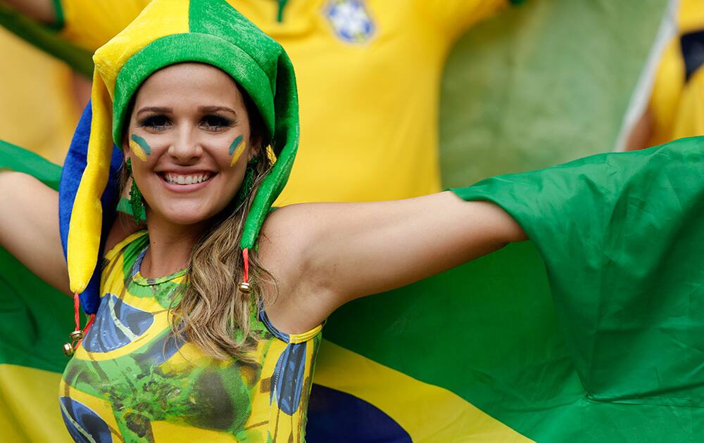 A Brazilian fan poses with her national flag before the group A World Cup soccer match between Brazil and Mexico at the Arena Castelao in Fortaleza, Brazil.