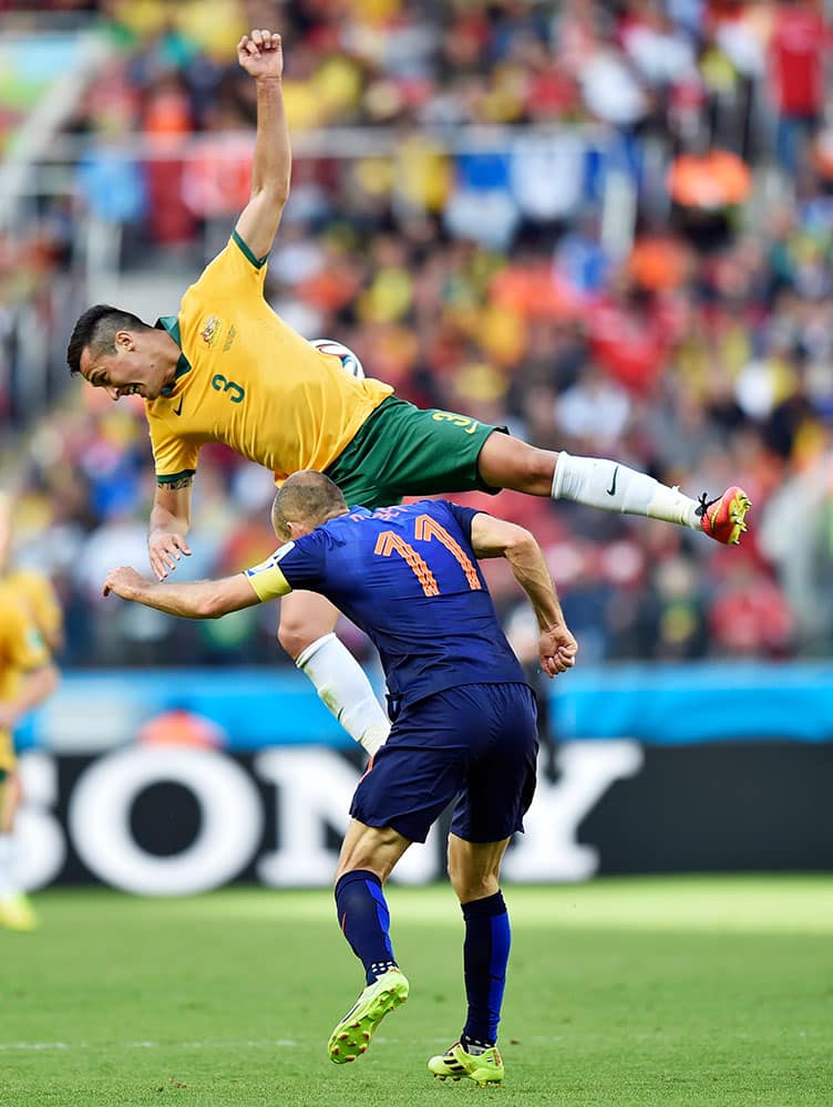 Australia's Jason Davidson, top, rises above Australia's Tommy Oar during the group B World Cup soccer match between Australia and the Netherlands at the Estadio Beira-Rio in Porto Alegre, Brazil.