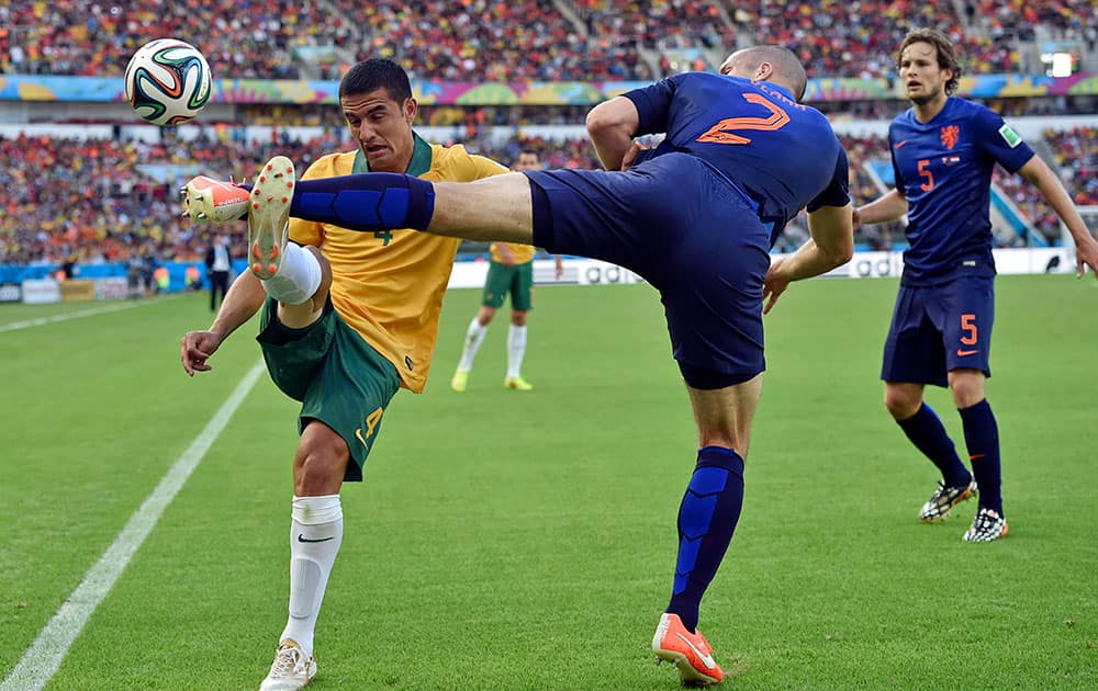 Australia's Tim Cahill, left, and Netherlands' Ron Vlaar battle for the ball during the group B World Cup soccer match between Australia and the Netherlands at the Estadio Beira-Rio in Porto Alegre, Brazil.