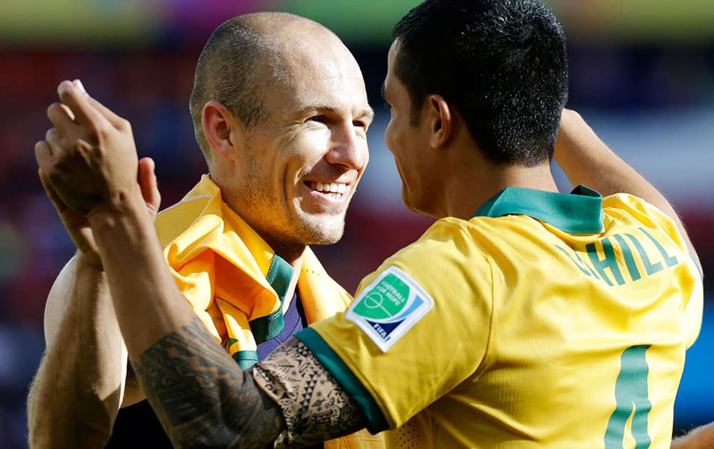 Netherlands' Arjen Robben, left, hugs Australia's Tim Cahill following the team's 3-2 loss to the Netherlands during the group B World Cup soccer match between Australia and the Netherlands at the Estadio Beira-Rio in Porto Alegre, Brazil.