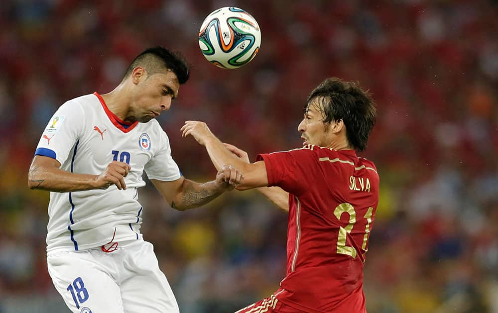 Chile's Gonzalo Jara, left, and Spain's David Silva battle for the ball during the group B World Cup soccer match between Spain and Chile at the Maracana Stadium in Rio de Janeiro, Brazil.