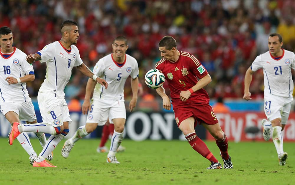 Spain's Fernando Torres, second from right, is surrounded by Chilean defenders during the group B World Cup soccer match between Spain and Chile at the Maracana Stadium in Rio de Janeiro, Brazil.