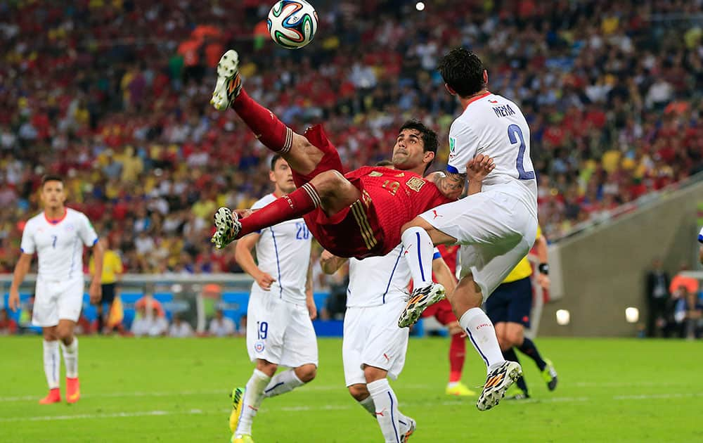 Spain's Diego Costa, left, kicks the ball during the group B World Cup soccer match between Spain and Chile at the Maracana Stadium in Rio de Janeiro, Brazil.