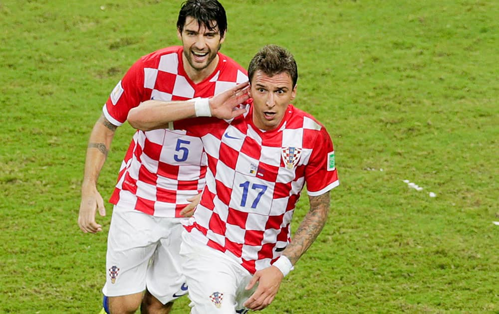 Croatia's Mario Mandzukic (17) celebrates with his teammate Vedran Corluka after scoring his side's third goal during the group A World Cup soccer match between Cameroon and Croatia at the Arena da Amazonia in Manaus, Brazil.