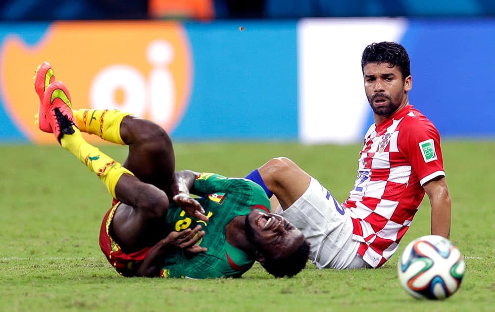 Cameroon's Edgar Salli, left, shouts out after being fouled by Croatia's Eduardo during the group A World Cup soccer match between Cameroon and Croatia at the Arena da Amazonia in Manaus, Brazil.