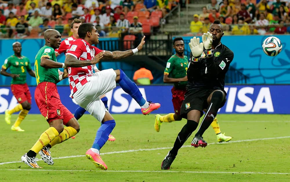 Croatia's Sammir, center, shoots wide of Cameroon's goalkeeper Charles Itandje, right, during the group A World Cup soccer match between Cameroon and Croatia at the Arena da Amazonia in Manaus, Brazil.