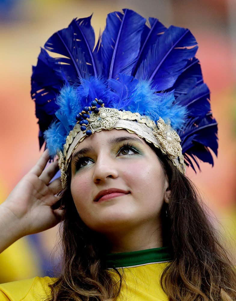 A spectator adjusts her headdress before the start of the group A World Cup soccer match between Cameroon and Croatia at the Arena da Amazonia in Manaus, Brazil.