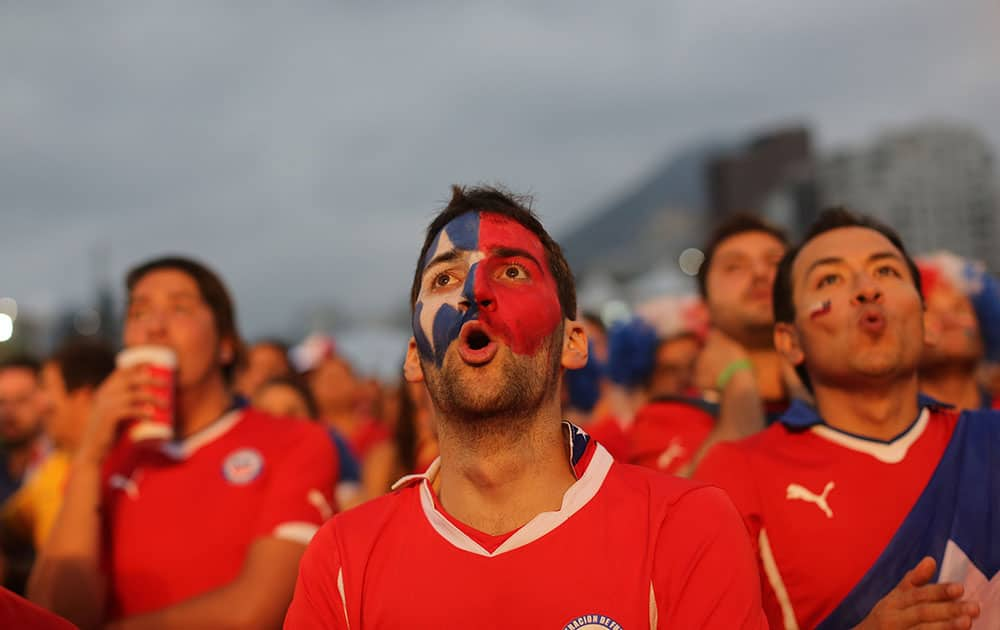 Soccer fans watch a live broadcast of the group B World Cup match between Chile and Spain, inside the FIFA Fan Fest area on Copacabana beach, in Rio de Janeiro, Brazil.