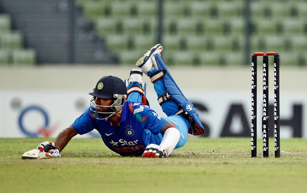 Cheteshwar Pujara dives to make his ground successfully during the third one-day International cricket match against Bangladesh in Dhaka.