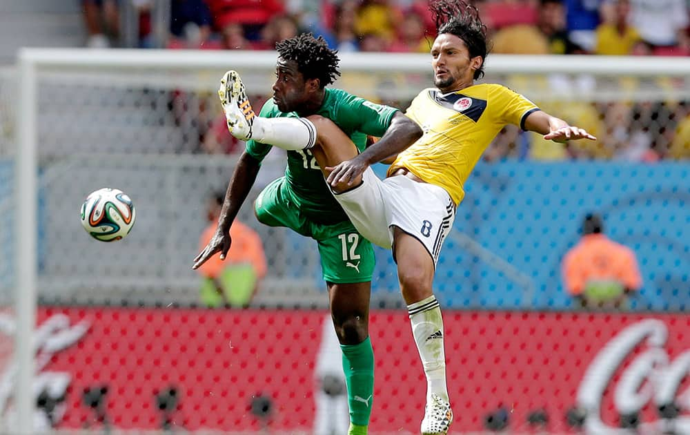 Ivory Coast's Wilfried Bony (12) and Colombia's Abel Aguilar (8) battle for the ball during the group C World Cup soccer match between Colombia and Ivory Coast at the Estadio Nacional in Brasilia.