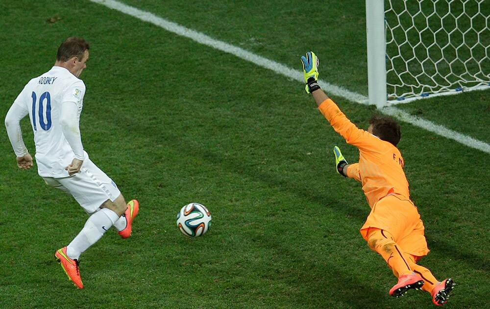 England's Wayne Rooney, left, scores his side's first goal past Uruguay's goalkeeper Fernando Muslera during the group D World Cup soccer match between Uruguay and England at the Itaquerao Stadium in Sao Paulo.