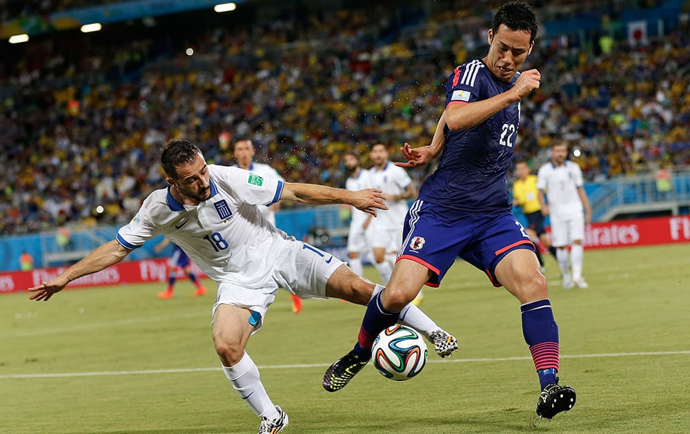 Greece's Giannis Fetfatzidis, left, challenges Japan's Maya Yoshida during the group C World Cup soccer match between Japan and Greece at the Arena das Dunas in Natal, Brazil.