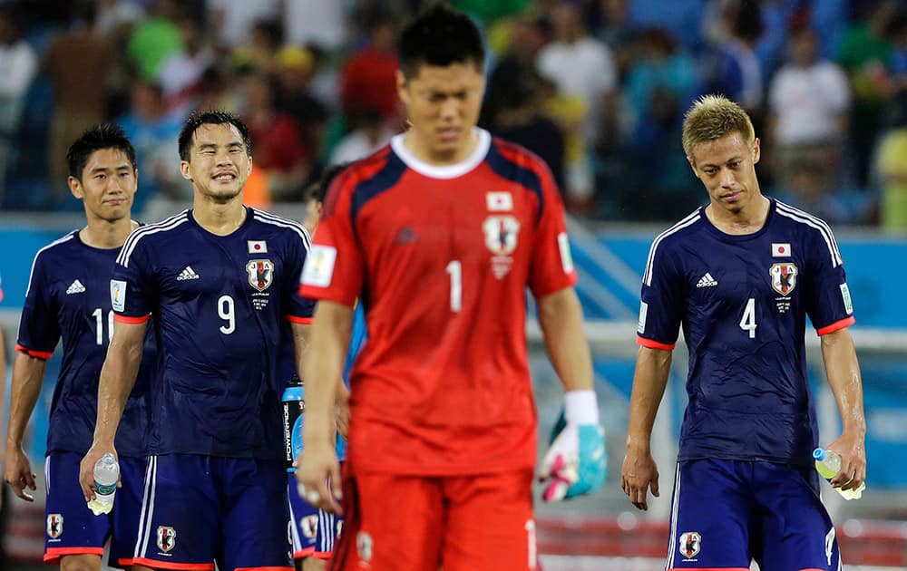 Japan's Shinji Kagawa, Shinji Okazaki, goalkeeper Eiji Kawashima and Keisuke Honda walk off the pitch after their 0-0 tie with Greece during the group C World Cup soccer match between Japan and Greece at the Arena das Dunas in Natal, Brazil.