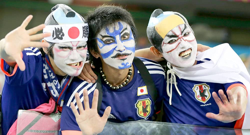 Japanese fans pose with their face paint before the group C World Cup soccer match between Japan and Greece at the Arena das Dunas in Natal, Brazil.