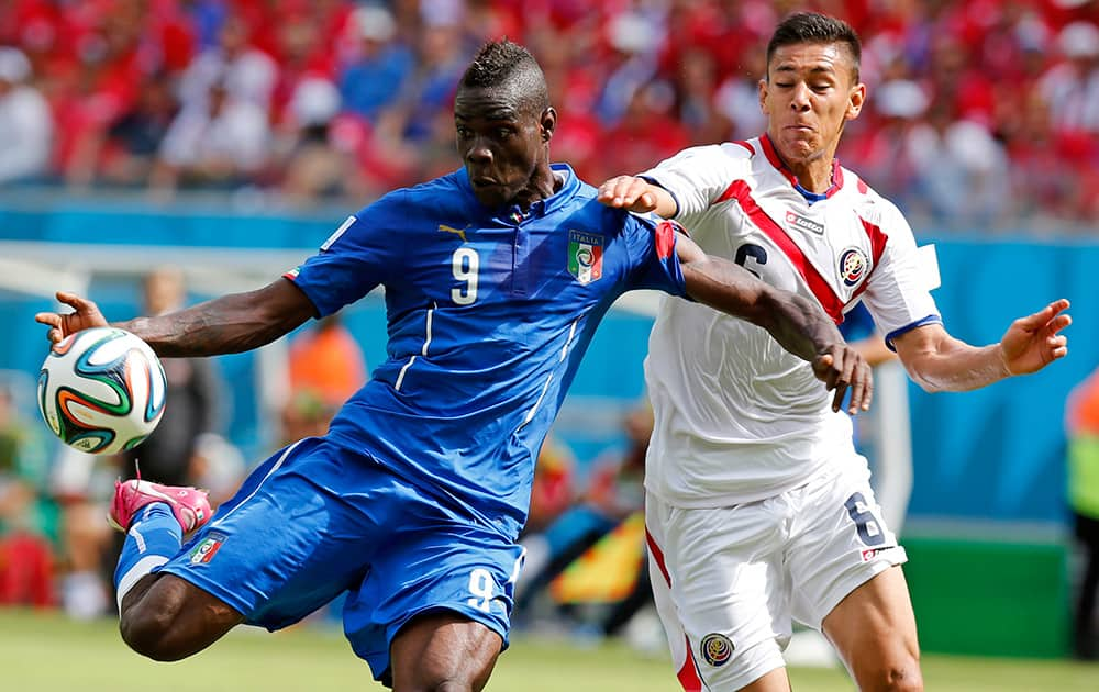 Italy's Mario Balotelli, left, gets in a shot despite the challenge of Costa Rica's Oscar Duarte during the group D World Cup soccer match between Italy and Costa Rica at the Arena Pernambuco in Recife