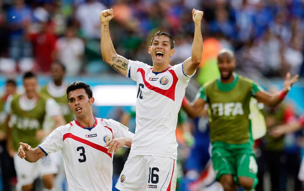 Costa Rica's Cristian Gamboa (16) and Giancarlo Gonzalez (3) celebrate with Oscar Duarte after the team's 1-0 victory over Italy during the group D World Cup soccer match between Italy and Costa Rica at the Arena Pernambuco in Recife, Brazil.