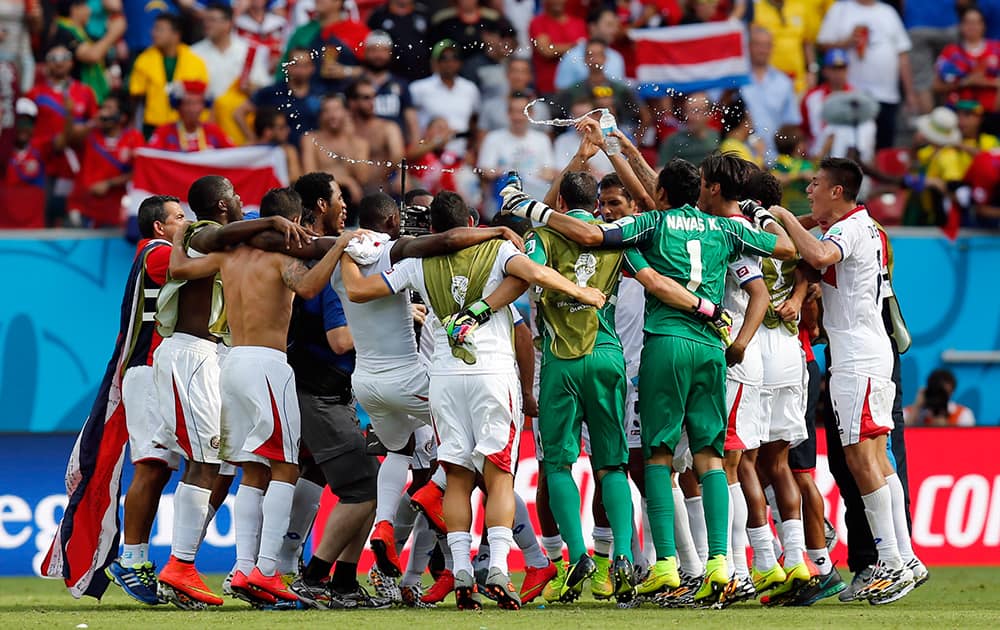 Costa Rican players celebrate after the group D World Cup soccer match between Italy and Costa Rica at the Arena Pernambuco in Recife, Brazil.