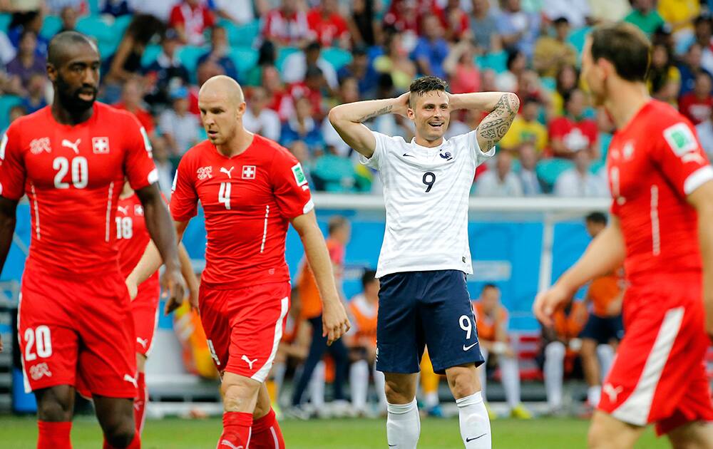 France's Olivier Giroud, second from right, smiles after missing a chance during the group E World Cup soccer match between Switzerland and France at the Arena Fonte Nova in Salvador, Brazil.