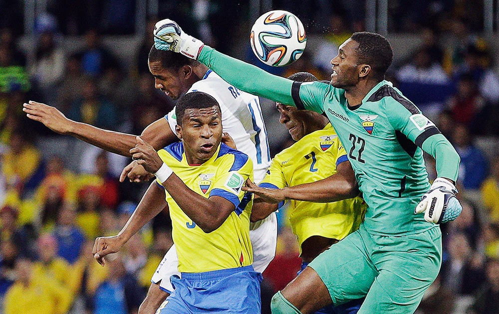 Ecuador's goalkeeper Alexander Dominguez, right, tries to punch the ball clear during the group E World Cup soccer match between Honduras and Ecuador at the Arena da Baixada in Curitiba, Brazil.