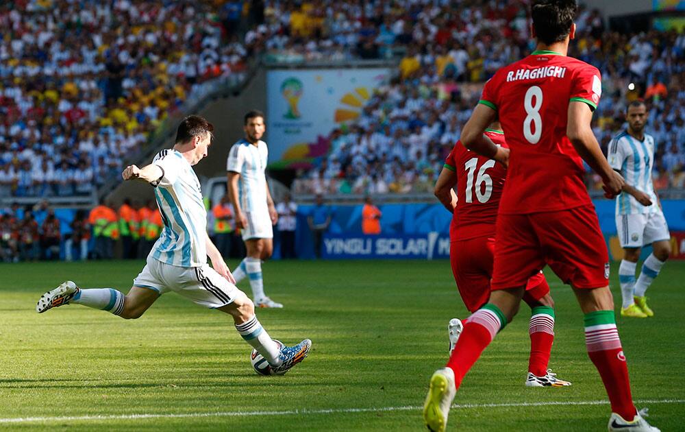 Argentina's Lionel Messi, left, scores during the group F World Cup soccer match between Argentina and Iran at the Mineirao Stadium in Belo Horizonte, Brazil.