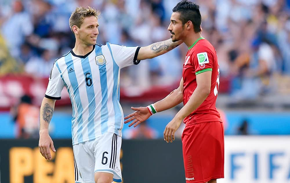 Iran's Reza Ghoochannejhad talks to Argentina's Lucas Biglia following Argentina's 1-0 victory over Iran during the group F World Cup soccer match between Argentina and Iran at the Mineirao Stadium in Belo Horizonte, Brazil.