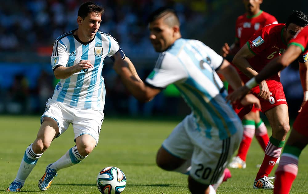 Argentina's Lionel Messi, left, controls the ball as his teammate Sergio Aguero runs, during the group F World Cup soccer match between Argentina and Iran at the Mineirao Stadium in Belo Horizonte, Brazil.