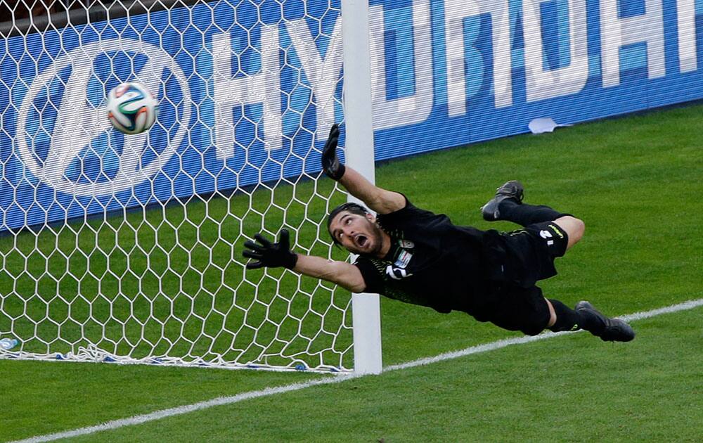 Iran's goalkeeper Rahman Ahmadi tries to stop a goal by Argentina's Lionel Messi during the group F World Cup soccer match between Argentina and Iran at the Mineirao Stadium in Belo Horizonte, Brazil.