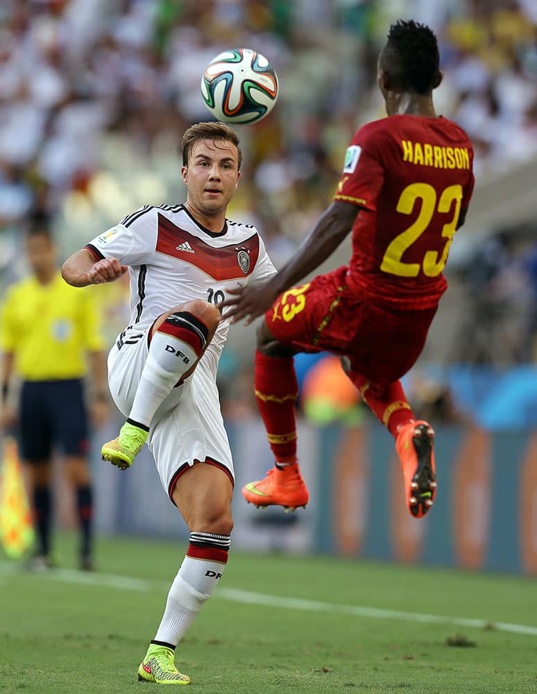 Ghana's Harrison Afful, right, comes in to block the ball from Germany's Mario Goetze during the group G World Cup soccer match between Germany and Ghana at the Arena Castelao in Fortaleza, Brazil.