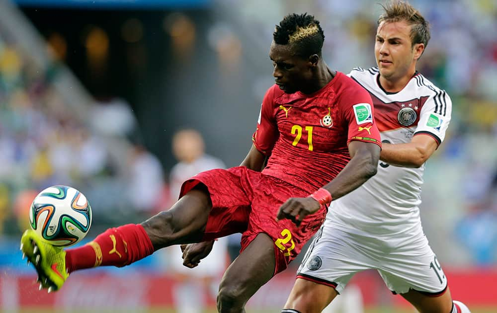 Ghana's John Boye, left, clears the ball from Germany's Mario Goetze during the group G World Cup soccer match at the Arena Castelao in Fortaleza, Brazil.