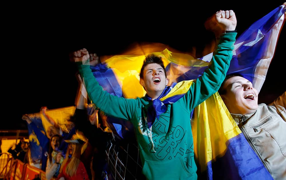 Supporters of Bosnia's soccer team cheer after watching a television broadcast of the 2014 World Cup match between Bosnia and Nigeria in Tuzla.