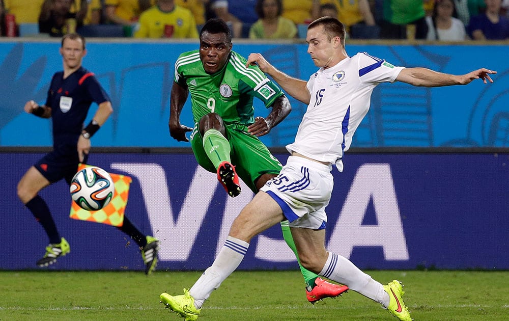 Nigeria's Emmanuel Emenike gets a shot off in front of Bosnia's Toni Sunjic during the group F World Cup soccer match between Nigeria and Bosnia at the Arena Pantanal in Cuiaba, Brazil.