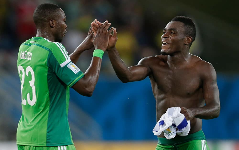 Nigeria's Shola Ameobi, left, and Nigeria's Emmanuel Emenike celebrate after the group F World Cup soccer match between Nigeria and Bosnia at the Arena Pantanal in Cuiaba, Brazil.