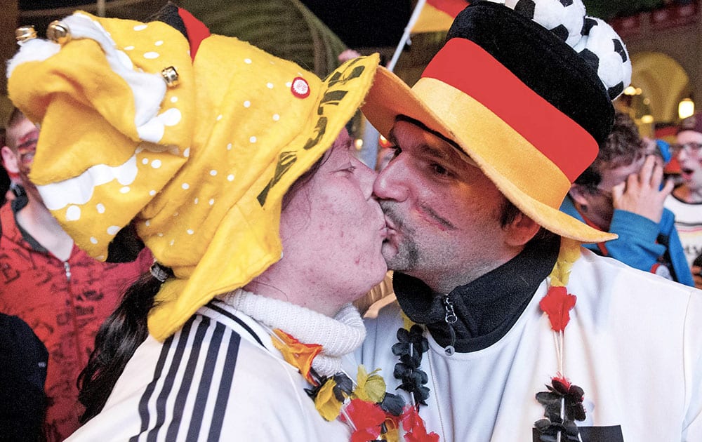 German soccer fans kiss after the kick off of their team during the soccer World Cup 2014 match Germany vs Ghana at a public viewing zone in Chemnitz, central Germany.